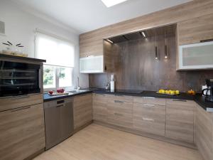 eine Küche mit Holzschränken und schwarzen Arbeitsplatten in der Unterkunft Holiday Home Nelli by Interhome in Calpe
