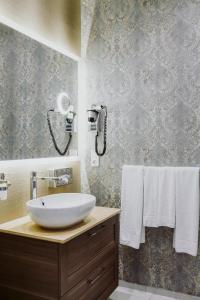 a bathroom with a sink, mirror, and bathtub at Garden Boutique Hotel in Berlin