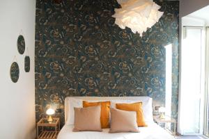 a bedroom with a bed and a wall with a wallpaper at Chilling'Monti in Rome