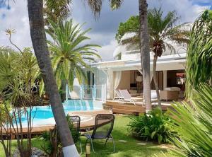 une maison avec une piscine et des palmiers dans l'établissement Villa Iguanou et piscine en bord de mer proche plages marina et golf, à Saint-François