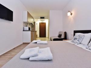 Azur Apartments - Nikiti Halkidiki في نيكيتي: غرفة نوم بسريرين عليها مناشف