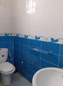 uma casa de banho com WC e uma parede de azulejos azuis em Diar Karim Djerba em Midoun