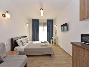 una camera d'albergo con un letto e una tv di Azur Apartments - Nikiti Halkidiki a Nikiti