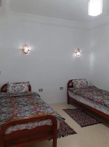 a bedroom with two beds and two rugs at Diar Karim Djerba in Midoun