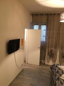 Zimmer mit einer Tür und einem TV an der Wand in der Unterkunft Affittacamere Real Fly in Bologna