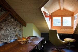 菲耶拉迪普里米耶羅的住宿－Mansarda in Centro，一间带木桌和窗户的用餐室