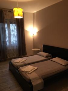 ボローニャにあるAffittacamere Real Flyのベッドルーム1室(ベッド2台、ランプ、窓付)