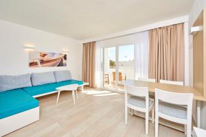 een woonkamer met een bank en een tafel en stoelen bij Sun Beach in Santa Ponsa