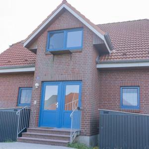 a red brick house with a blue door at Ruhe-Insel in Lemkenhafen auf Fehmarn