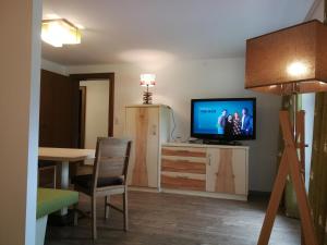 a living room with a television and a dining room table at Zugspitz-Arena Fewo Haus Schachtkopf in Biberwier