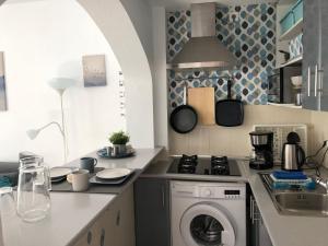 a kitchen with a washing machine and a sink at Apartamento Trinidad mit Netflix in Fuengirola