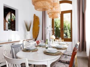 uma sala de jantar branca com uma mesa e cadeiras brancas em Villa Can Moya em Palma de Maiorca