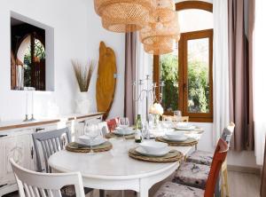 a white dining room with a white table and chairs at Villa Can Moya in Palma de Mallorca