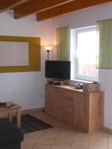ein Wohnzimmer mit einem TV auf einem Holzschrank in der Unterkunft Ferienanlage Karolinenhof 2 in Haundorf