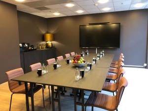 Rømskog Spa & Resort - Unike Hoteller في Rømskog: قاعة اجتماعات مع طاولة كبيرة مع وعاء من الفواكه