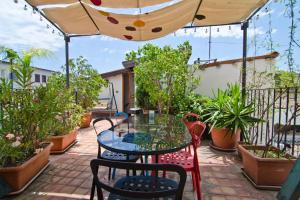 une terrasse avec une table et des chaises sous un parasol dans l'établissement BAD - B&B And Design, à Catane