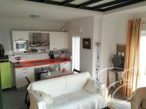 sala de estar con sofá blanco y cocina en First line beach apartment, en Algarrobo