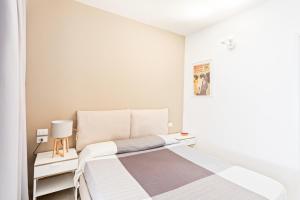1 dormitorio blanco con 1 cama y 2 mesitas de noche en Luminoso Nuovalucello Apart- Giardino e Parcheggio privato, en Catania