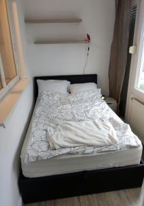 an unmade bed in a room with a window at Apartment in quiet area with free parking in Varaždin