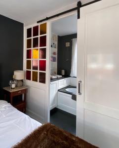 ein Schlafzimmer mit einer Tür, die sich zu einem Bad mit einem Bett öffnet in der Unterkunft The Lastage Inn - Bed & Breakfast in Amsterdam