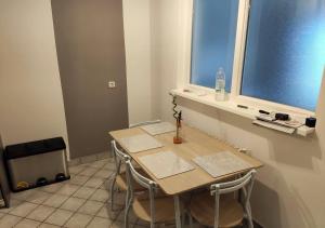 a table and chairs in a room with a window at Apartment in quiet area with free parking in Varaždin