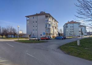 a parking lot with cars parked in front of a building at Apartment in quiet area with free parking in Varaždin