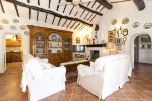a living room with two white chairs and a fireplace at Villa La Liccia Misia in Santa Teresa Gallura
