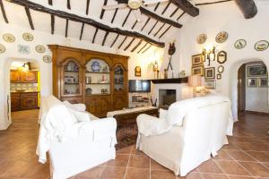 sala de estar con 2 sillas blancas y chimenea en Villa La Liccia Misia, en Santa Teresa Gallura