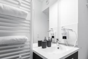 Student Factory Paris Bagnolet في بانيوليه: حمام أبيض مع حوض ومرآة