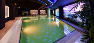 a swimming pool in a building with a green and white at Altın Otel & Spa Balıkesir in Balıkesir