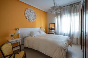 Un dormitorio con una gran cama blanca y una ventana en Casa Angel en Cáceres