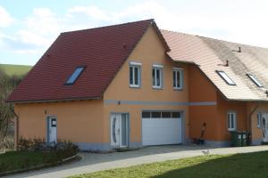 una casa con techo rojo y garaje en Pferdefreunde Loberhof en Weihenzell