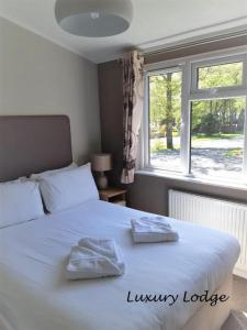 a bedroom with a white bed with two towels on it at Inverbeg Holiday Park in Luss