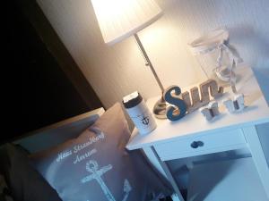 a nightstand with a table with a lamp and a sign on it at Haus Strandburg Amrum in Wittdün