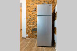 a white refrigerator in a room with a stone wall at Paraspori Traditional Home with View in Paraspórion