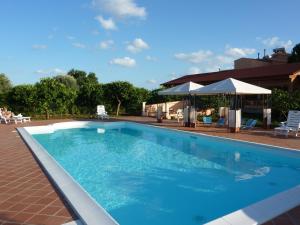 Case Monterosso的住宿－里莫尼托農家樂，一座大型蓝色游泳池,位于大楼旁边
