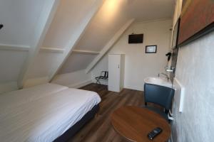 a bedroom with a bed and a table and a sink at Hotel Hortus in Amsterdam