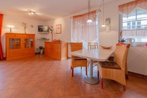Una cocina y un comedor con mesa y sillas. en Ferienwohnung Strandrose, en Thiessow