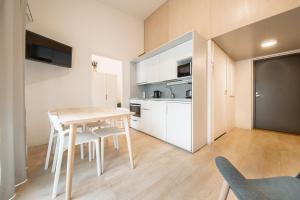 Una cocina con una mesa y sillas en una habitación. en Spot Apartments Martinlaakso, en Vantaa