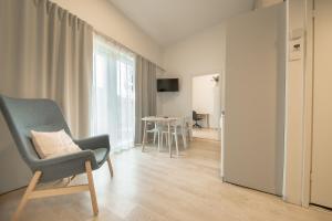 Una sala de estar con una silla y una mesa. en Spot Apartments Martinlaakso, en Vantaa