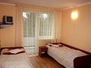 a hotel room with two beds and a window at Uzdrowisko Muszyna nad Popradem in Muszyna