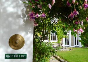 a house with a door with a sign on it at Delphi Lodge in Leenaun