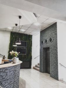 a kitchen with a brick wall with a plant at TeleDom Hotel in Košice