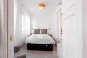 a white bedroom with a bed with white sheets at Apartamento Santa Maria by Be Alicante in Alicante