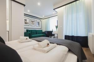 Un dormitorio con dos camas y un sofá verde. en City Break Atelier Praga Apartamenty, en Varsovia