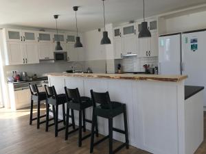 a kitchen with white cabinets and black bar stools at Chalupa U Kačírků in Horní Planá +17 photos