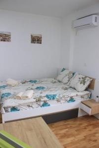 a bed in a room with a white wall at Apartments S*A in Ohrid
