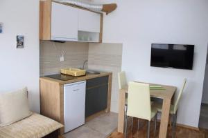 a small kitchen with a sink and a table with chairs at Apartments S*A in Ohrid
