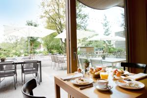 a table with food on it with a view of a patio at Hotel Schwärzler in Bregenz