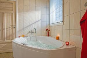 La salle de bains est pourvue d'une grande baignoire et d'une fenêtre. dans l'établissement Schlosspark Bad Saarow, à Bad Saarow
